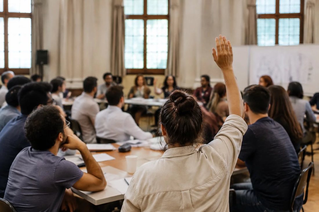 Dupla organizando o roteiro de um debate com cadernos e canetas marca-texto